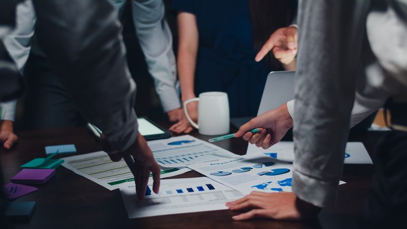A team reviewing analysis and performance reports around a table