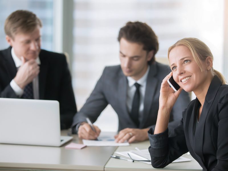 A consultant taking a client call in a meeting room