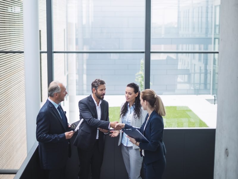 Experts meeting with a handshake in a bright office atrium