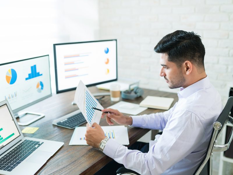 Analyst reviewing performance charts at a desk